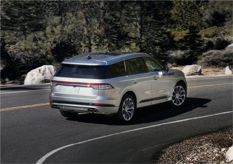 A 2023 Lincoln Aviator® Grand Touring model is shown being driven on a tight turn of a mountain road | J.C. Lewis Lincoln in Savannah GA