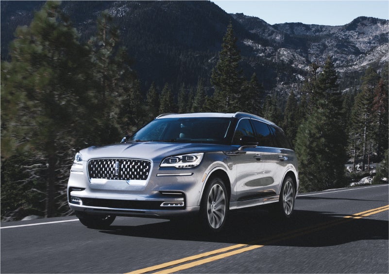 A 2023 Lincoln Aviator® Grand Touring SUV being driven on a winding road to demonstrate the capabilities of all-wheel drive | J.C. Lewis Lincoln in Savannah GA