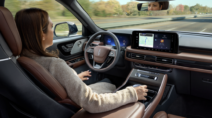 A woman is seen sitting in the driver’s seat of her 2025 Lincoln Aviator® SUV with her hands off the steering wheel. | J.C. Lewis Lincoln in Savannah GA