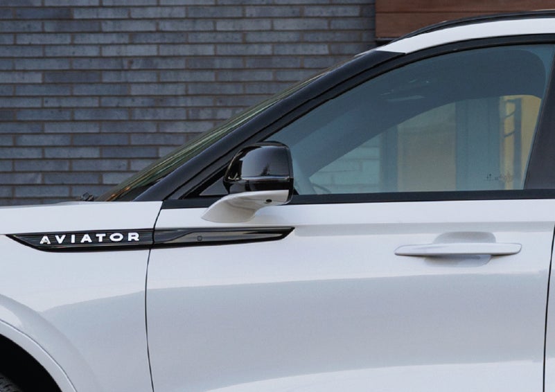 The driver’s side door and fender badging of a white 2026 Lincoln Aviator® SUV are showcased. | J.C. Lewis Lincoln in Savannah GA