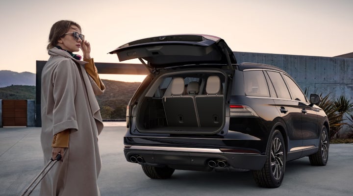 A woman approaches a 2026 Lincoln Aviator® SUV with its rear liftgate open. | J.C. Lewis Lincoln in Savannah GA