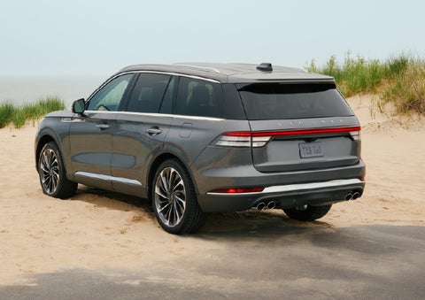 A 2027 Lincoln Aviator® SUV is parked next to sand dunes. | J.C. Lewis Lincoln in Savannah GA