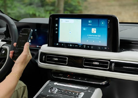 A person pairs thier phone with the center touchscreen of a 2027 Lincoln Aviator® Black Label™ SUV | J.C. Lewis Lincoln in Savannah GA